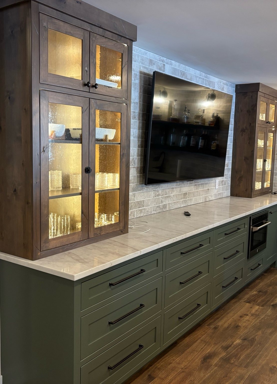 Green inset entertainment cabinetry with stained display towers